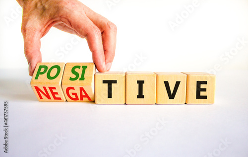Positive or negative symbol. Businessman turns wooden cubes and changes the word 'negative' to 'positive'. Beautiful white table, white background. Business, positive or negative concept. Copy space.