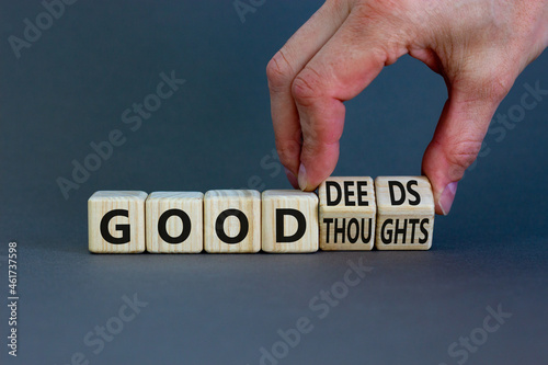 Good thoughts and deeds symbol. Businessman turns wooden cubes and changes words 'good thoughts' to 'good deeds'. Beautiful grey background, copy space. Business and good thoughts and deeds concept.