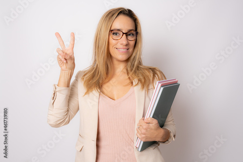 Cheerful young business woman isolated on white background studio with victory sign. Achievement career wealth business concept.