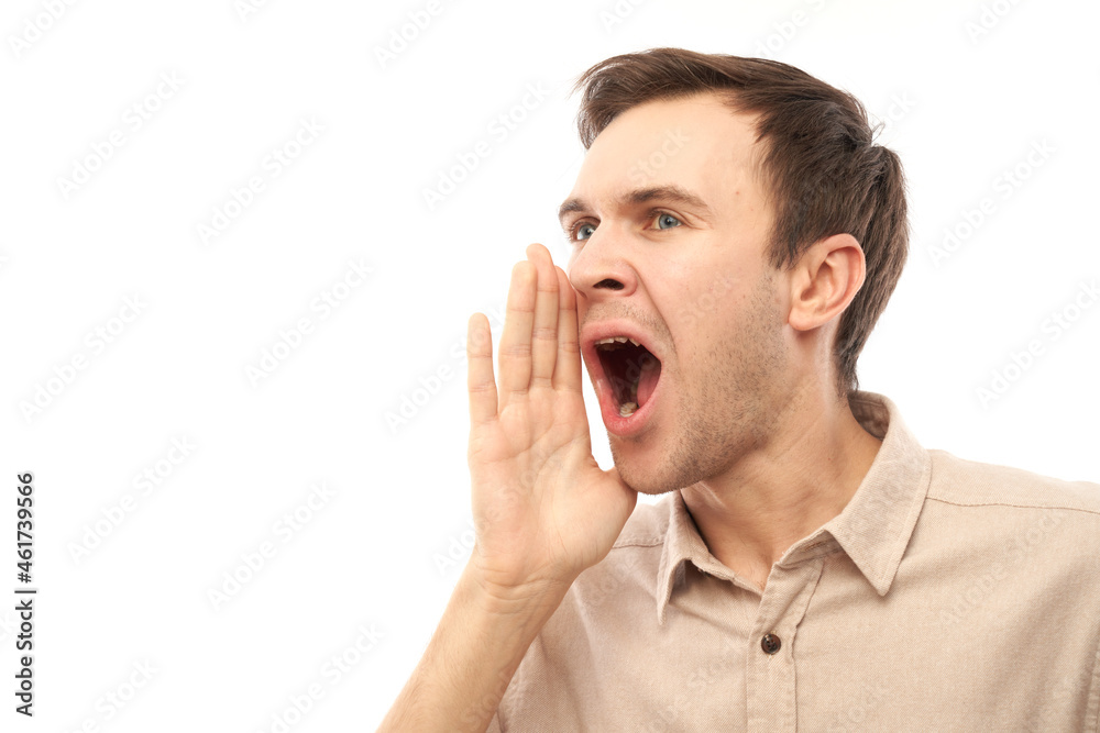 Handsome happy young caucasian male shouting and cupping hands around mouth isolated on white studio background. Excited news attention! Handsome happy young caucasian male shouting and cupping hands around mouth isolated on white studio background. Excited news attention!