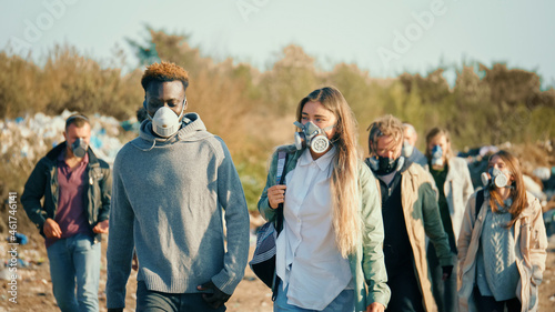 Group of Young People in Gas Masks Going Through the Toxic Smoke in a Garbage Dump. People Care About Ecology. Young Activists in Action Against Pollution Stay at a Landfill Site. Saving the Planet.