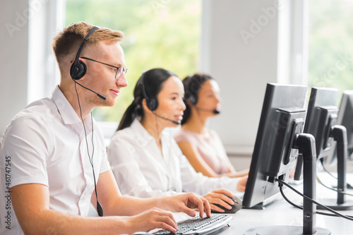 Diverse team of young professionals is working in the phone support office. Working day of sales managers in the call center. Business, telephone consulting and problem solving.