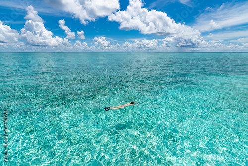 Fototapeta Naklejka Na Ścianę i Meble -  Woman snorkeling in clear tropical waters in front of exotic island