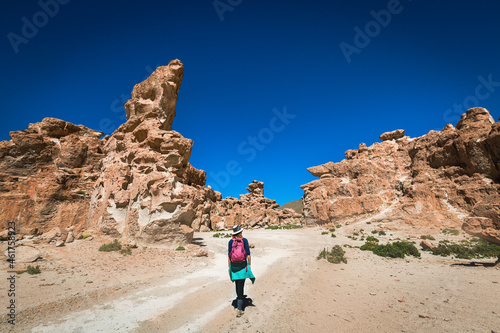 A girl in a hat walks in the valley of stones. Bolivia