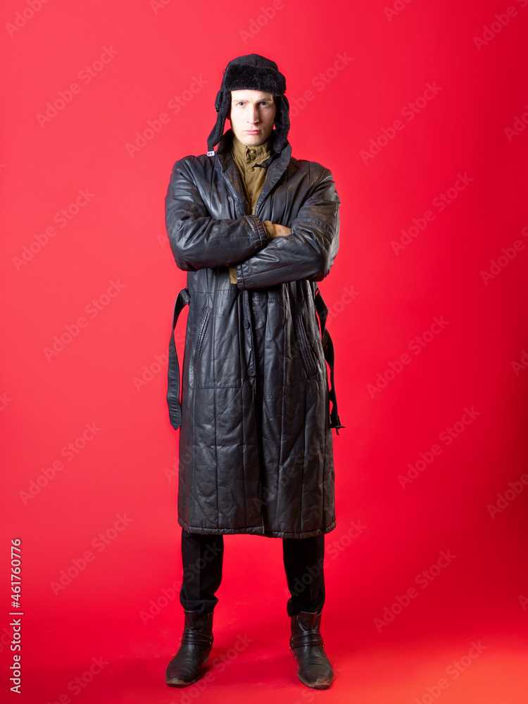 A man in old-fashioned clothes and a hat with earflaps, Russian post-war style. A man in old-fashioned clothes and a hat with earflaps, Russian post-war style.