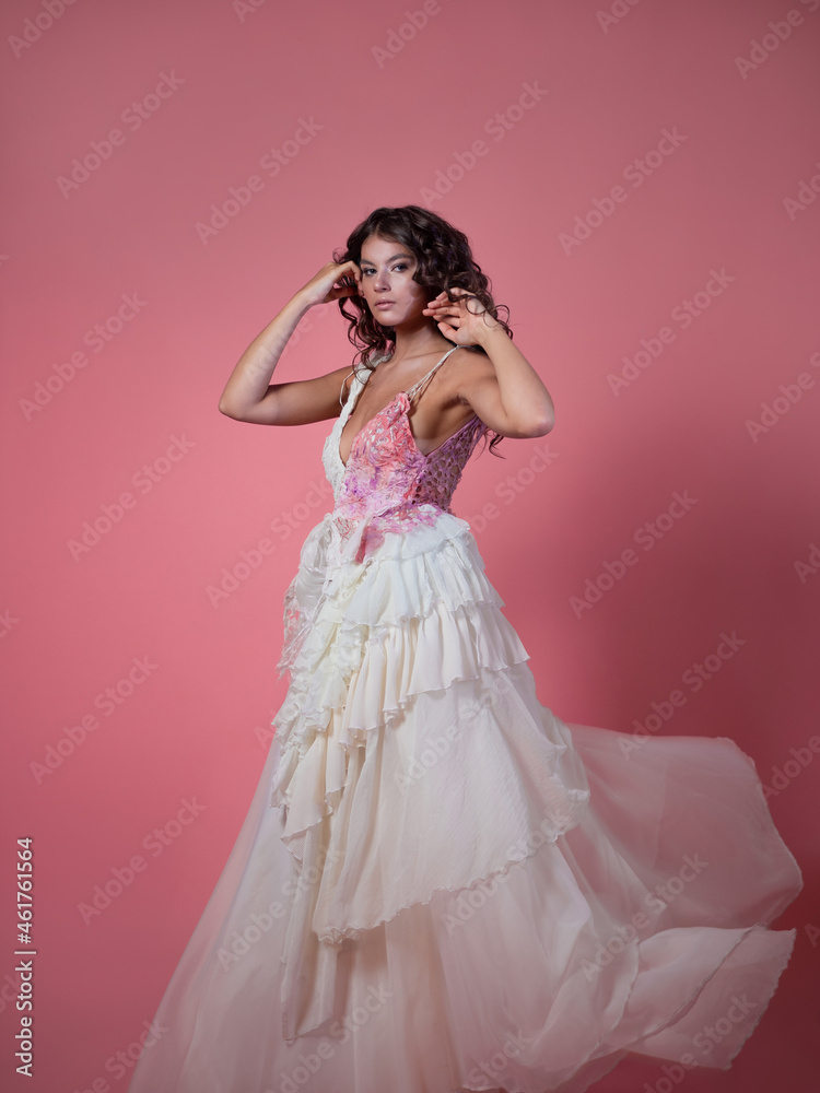 A beautiful young brunette with long curls in a fabulous image,