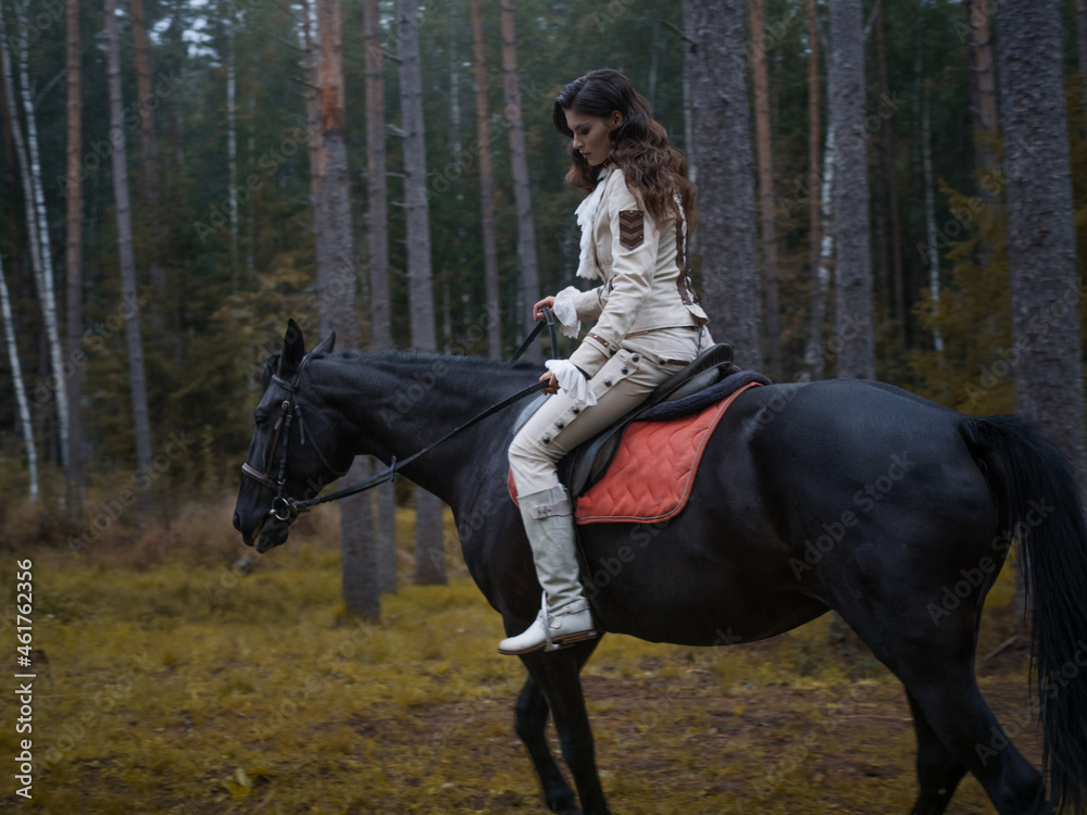 A young beautiful brunette rider in an elegant retro suit riding a black horse A young beautiful brunette rider in an elegant retro suit riding a black horse
