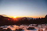 Winter calm mountain landscape at sunset. Splendid snow-covered mountains view with beautiful fir trees on slope