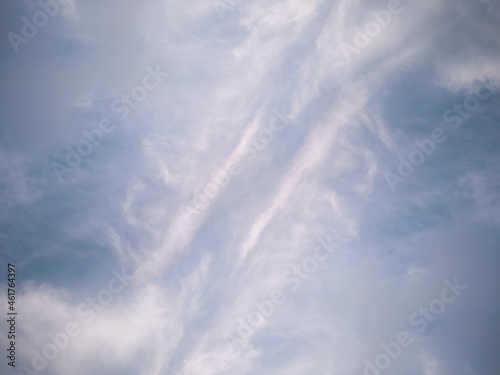 A fragment of the blue sky covered with white cirrus symmetrical clouds. Texture. Background. © TETIANA