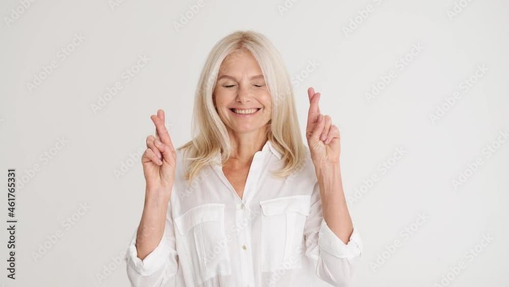 Smiling mature woman hoping for something in the white studio Smiling mature woman hoping for something in the white studio