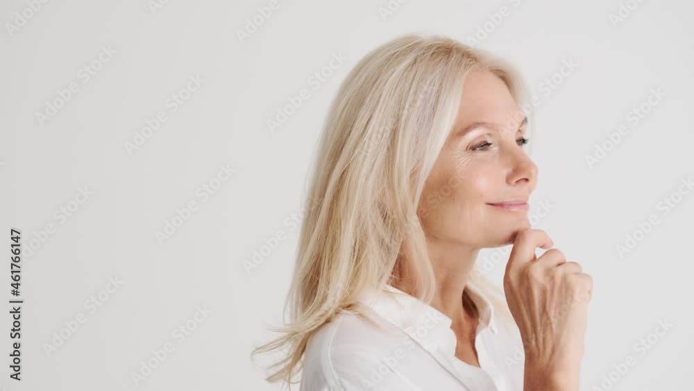 Side view of the smiling mature woman in the white studio Side view of the smiling mature woman in the white studio