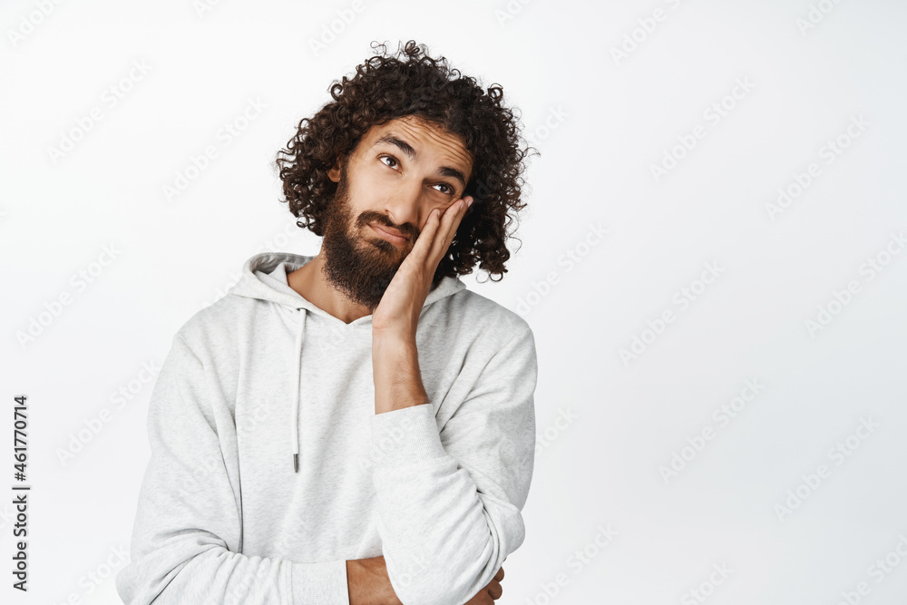 Bored hispanic man roll eyes, lay head on hand annoyed, unamused and uninterested, standing over white background Bored hispanic man roll eyes, lay head on hand annoyed, unamused and uninterested, standing over white background