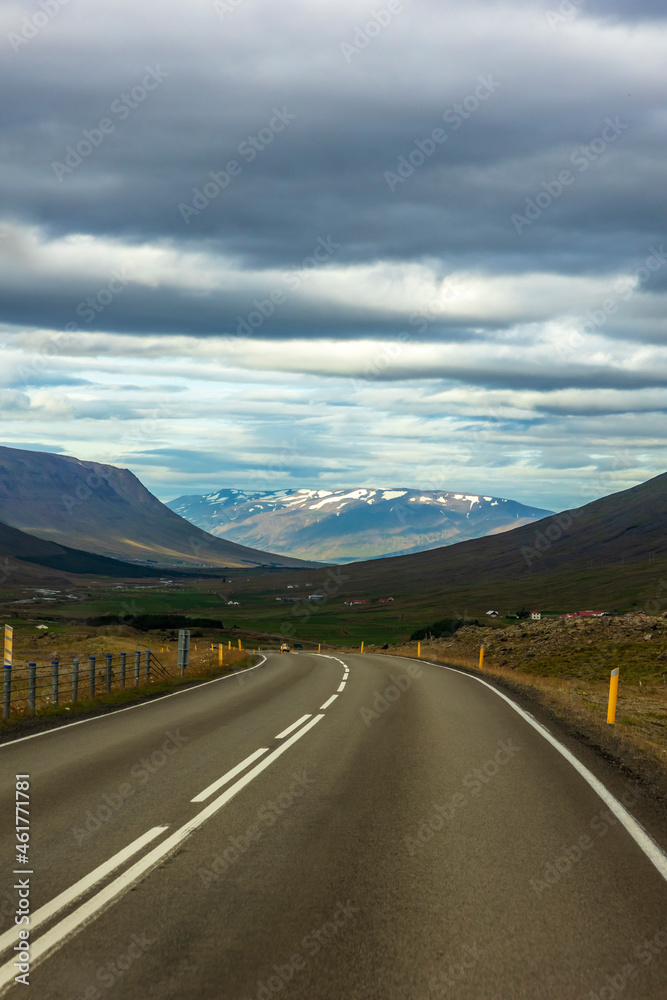 summer road trip on open hi-way  in Route 1 in Iceland with dramatic mountain landscapes on the background.