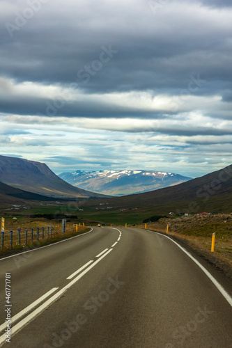 summer road trip on open hi-way in Route 1 in Iceland with dramatic mountain landscapes on the background.