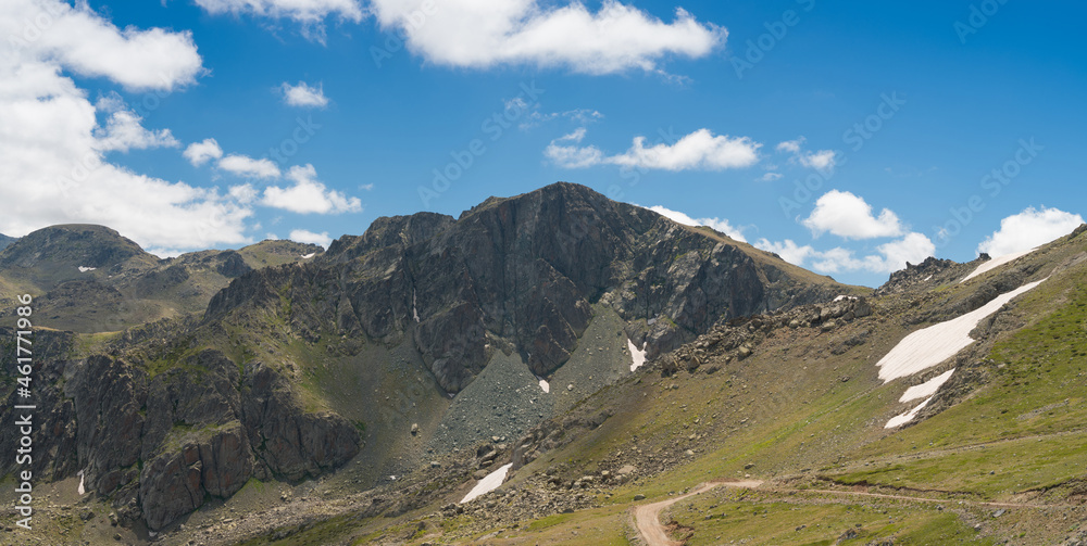 Mountains in summer. Image of blue sky and hills. Melted snow and rocks. 