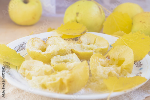 Baked yellow apples on a plate in autumn with autumn yellow leaves