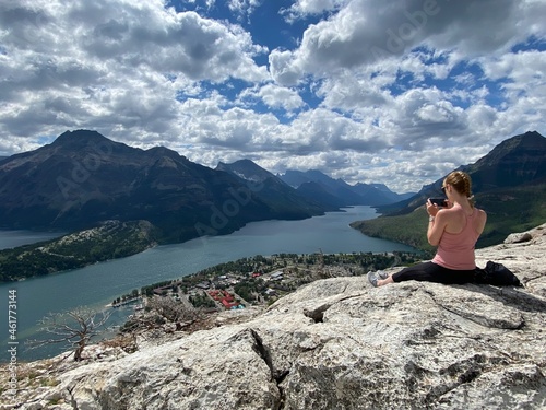 Canvas Print A blonde woman taking pictures at the top of Bear's Hump in Waterton Alberta