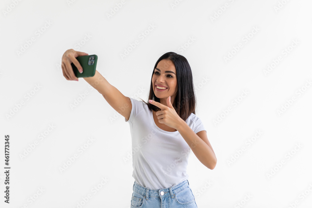 Portrait of a smiling woman making selfie photo on phone isolated on a white background Portrait of a smiling woman making selfie photo on phone isolated on a white background