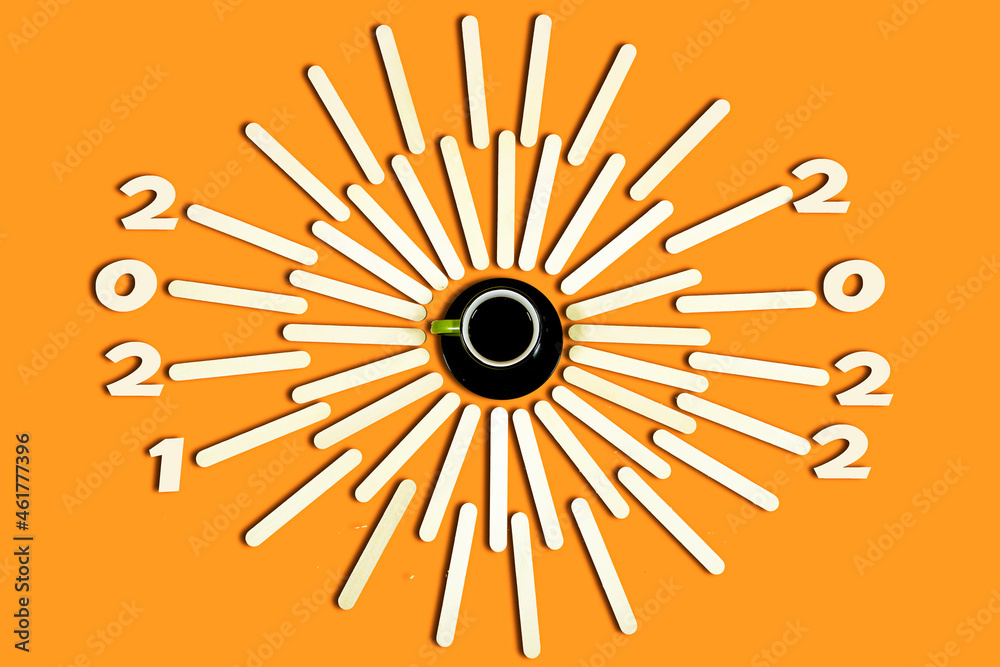 Happy new year 2022. creative image with Cup of coffee around wooden stick, change 2021 to 2022 on the background. Start concept Happy new year 2022. creative image with Cup of coffee around wooden stick, change 2021 to 2022 on the background. Start concept