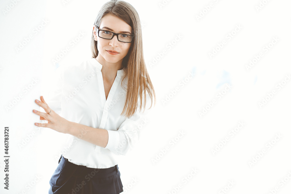 Beautiful female specialist with copy space area standing in modern office and smiling charmingly. Working on design, data analysis, plan strategy. Business people concept Beautiful female specialist with copy space area standing in modern office and smiling charmingly. Working on design, data analysis, plan strategy. Business people concept