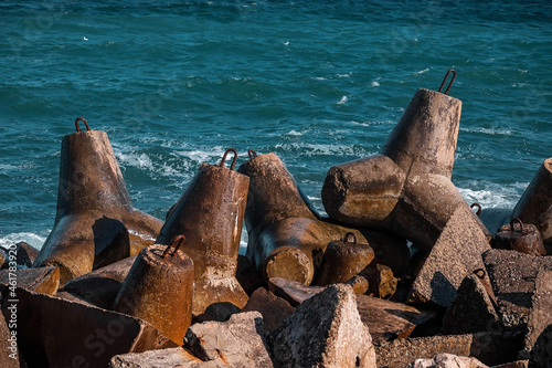 Strengthening the shore from erosion. Seashore with concrete blocks. The element of water. Waves break on concrete.