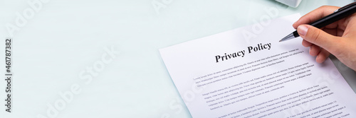 Woman Holding Pen Over Privacy Policy Form photo