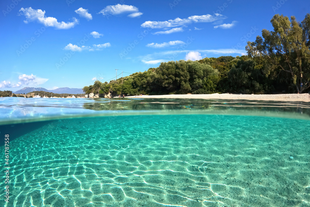 Fototapeta premium Underwater split photo of famous bay and sandy turquoise beach of Fanari with crystal clear calm sea and rich aquatic life in Ionian island of Meganisi, Greece