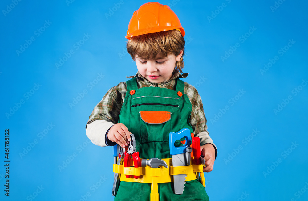 Child in helmet and in builder uniform with tool belt. Kid boy repairman with tools for building. Child in helmet and in builder uniform with tool belt. Kid boy repairman with tools for building.