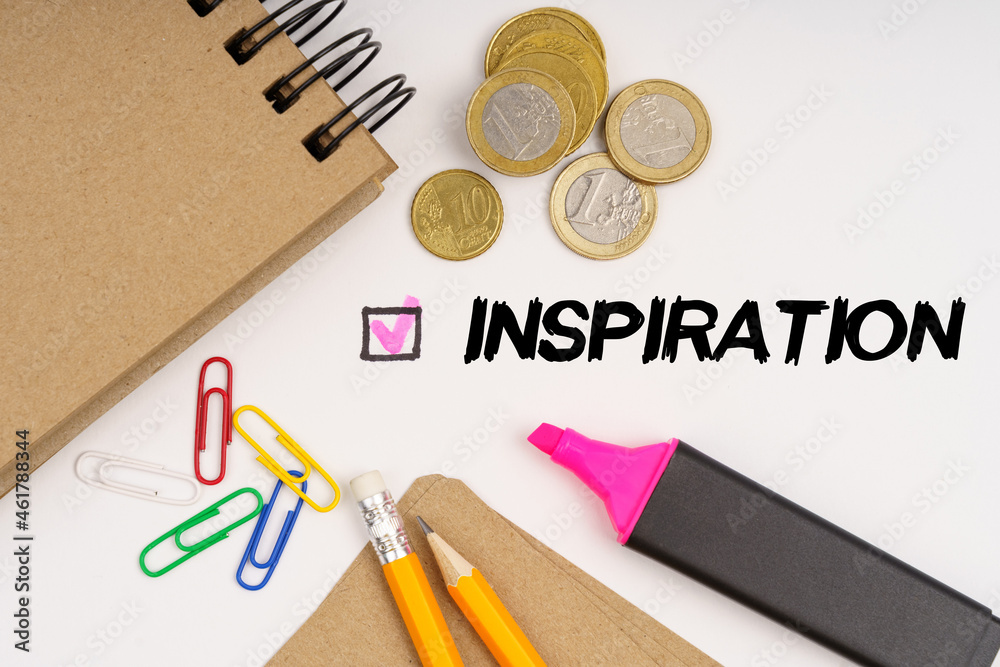 On a white background notepads, paper clips, coins, pencils and the inscription - INSPIRATION On a white background notepads, paper clips, coins, pencils and the inscription - INSPIRATION