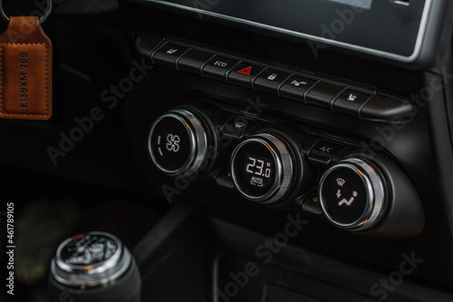 Color car air conditioning buttons close up view inside a car. Car temperature conditioner dashboard panel. © Roman