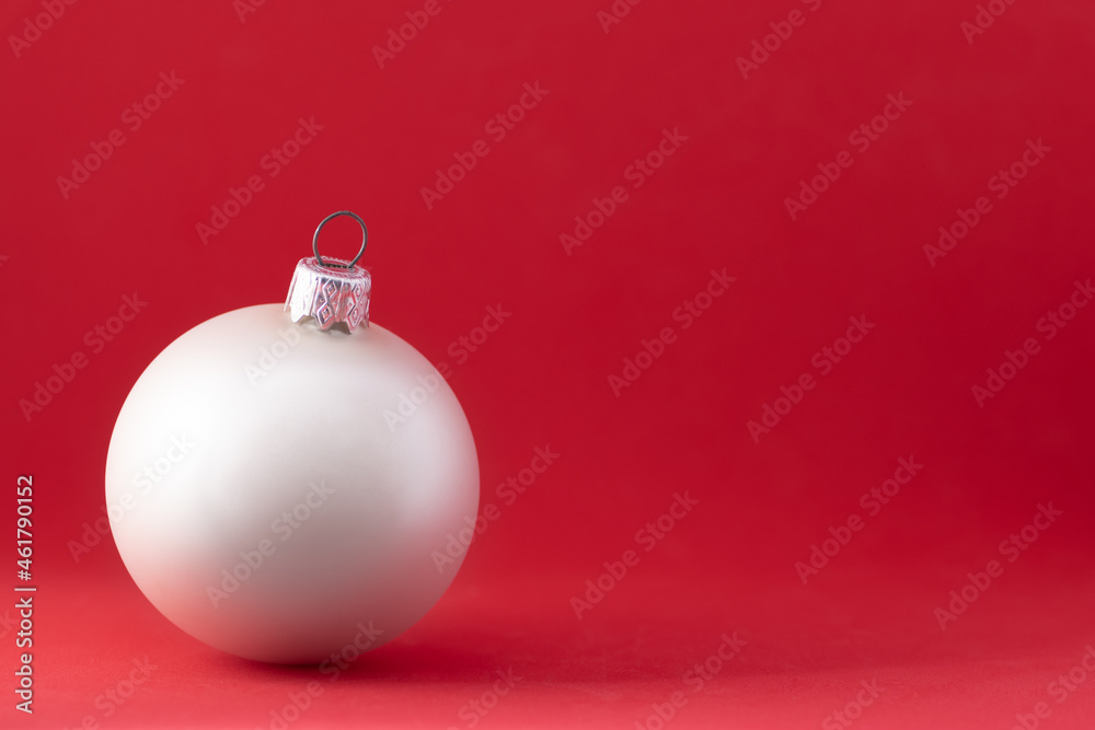 Christmas bauble on red background. Copy space for text on holiday card with white Christmas ball. Elegant red christmas ornament. Merry Christmas and happy new year concept Christmas bauble on red background. Copy space for text on holiday card with white Christmas ball. Elegant red christmas ornament. Merry Christmas and happy new year concept