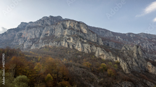 Rocky cliff  autumn colored trees and blue sky above canyon of Jerma river in Serbia