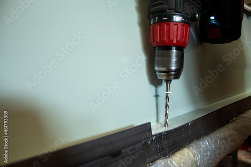 Metal drilling closeup in metal workshop. Drilling machine making a hole in a steel bar