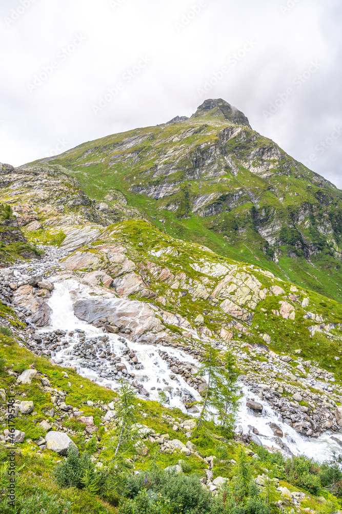 Wild alpine waterfall on Schlatenbach mountain stream. Gschloesstal Valley, Hohe Tauern National Park, East Tyrol, Austrian Alps