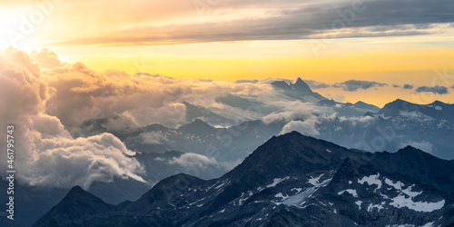 Rocky alpine mountains morning panorama. Cloudy sunrise on summer day. Grossglockner Mountain  Hohe Tauern National Park  Austrian Alps