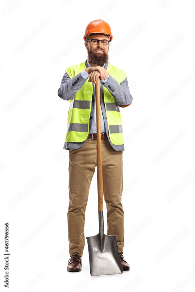 Site engineer with a vest and a helmet leaning on a shovel