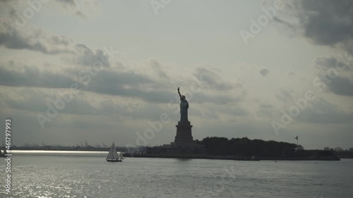 Statue of liberty and sailing boat at the sunset. Travel industry, democracy and freedom concept