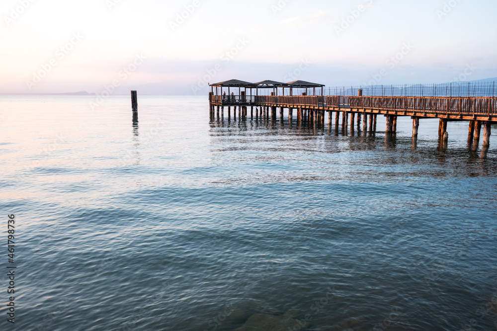 A beautiful sunset on Lago di Garda near the wooden jetty.