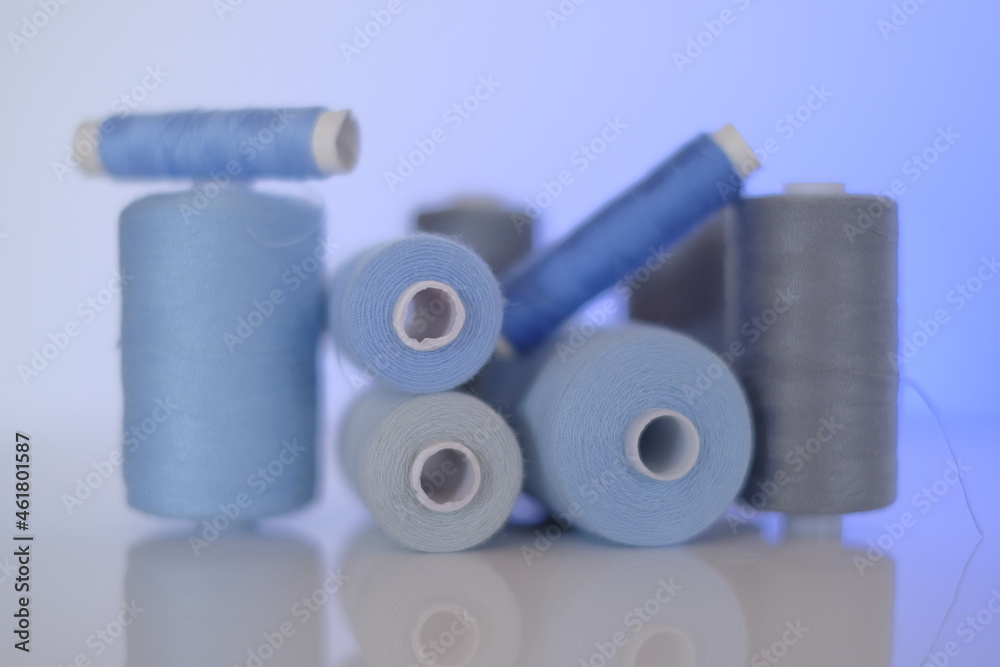 thread spools. Sewing threads set.Blue and gray thread spools on a light blue background.Needlework and sewing.Hobby and handicraft thread spools. Sewing threads set.Blue and gray thread spools on a light blue background.Needlework and sewing.Hobby and handicraft