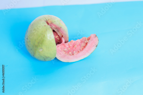 Fresh sliced guava and leaves or Psidium guava, isolated on blue. Selective Focus. photo