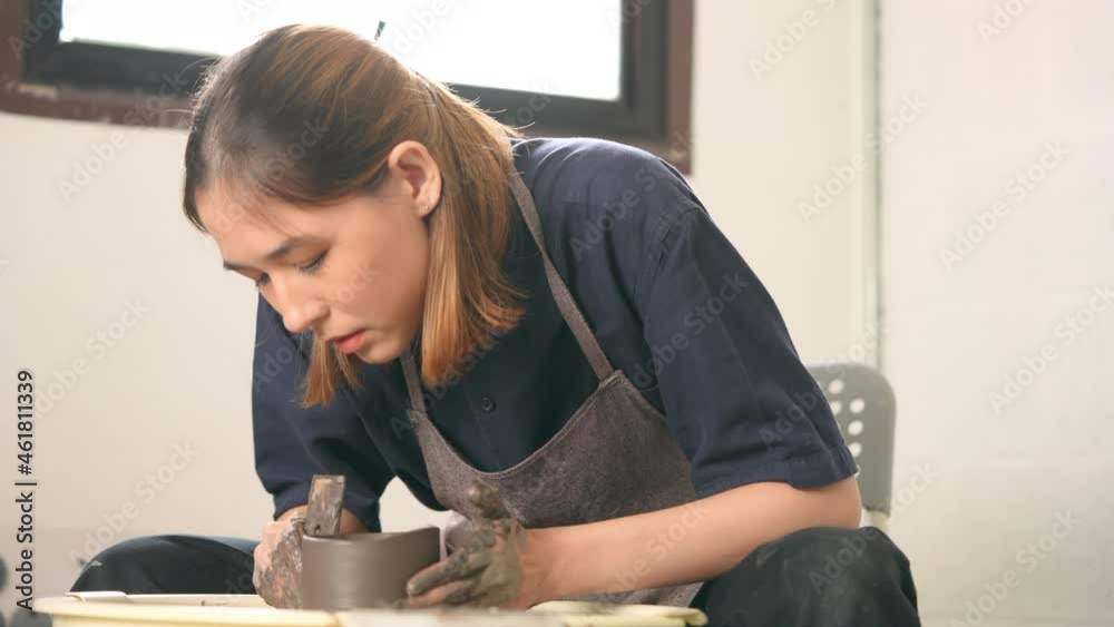 4K Asian woman sculptor artist hands sculpture clay on pottery wheel at ceramic studio. Female craftsman molding raw clay create pottery shapes at workshop. Small business handicraft product concept. 4K Asian woman sculptor artist hands sculpture clay on pottery wheel at ceramic studio. Female craftsman molding raw clay create pottery shapes at workshop. Small business handicraft product concept.