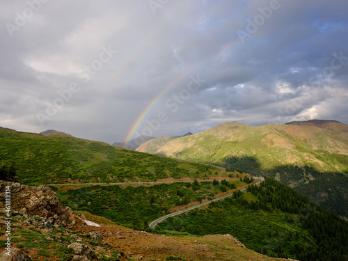 Colorful Rainbow and a two-lane highway cut through Independence Pass and the Continental divide in Colorado
