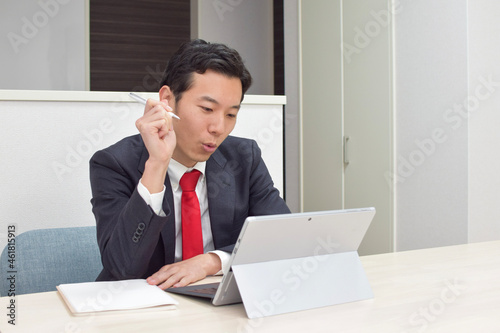 A young Asian man during telework at home thinks about new idea and comes up with the idea