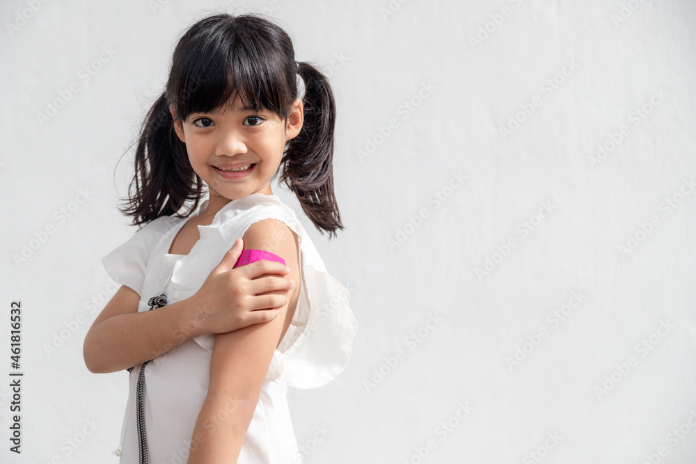 Asian little girl showing his arm after got vaccinated or inoculation, child immunization, covid delta vaccine concept Asian little girl showing his arm after got vaccinated or inoculation, child immunization, covid delta vaccine concept