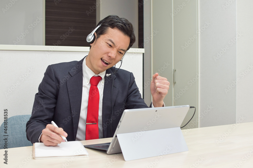A young Asian man wearing a headset gets angry at his customer during telework at home A young Asian man wearing a headset gets angry at his customer during telework at home