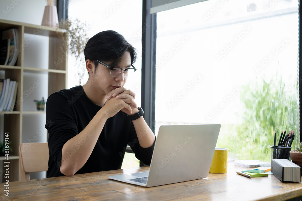 Thoughtful young man designer checking information on laptop computer. Thoughtful young man designer checking information on laptop computer.