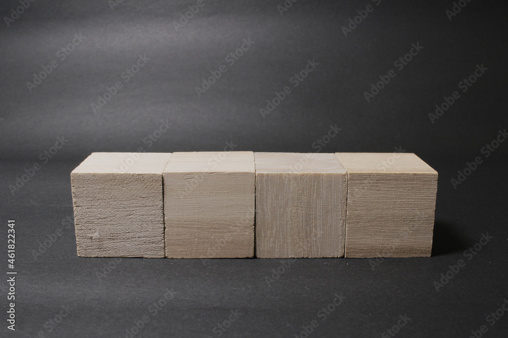 a wooden cube isolated on a dark background - obrazy, fototapety, plakaty 