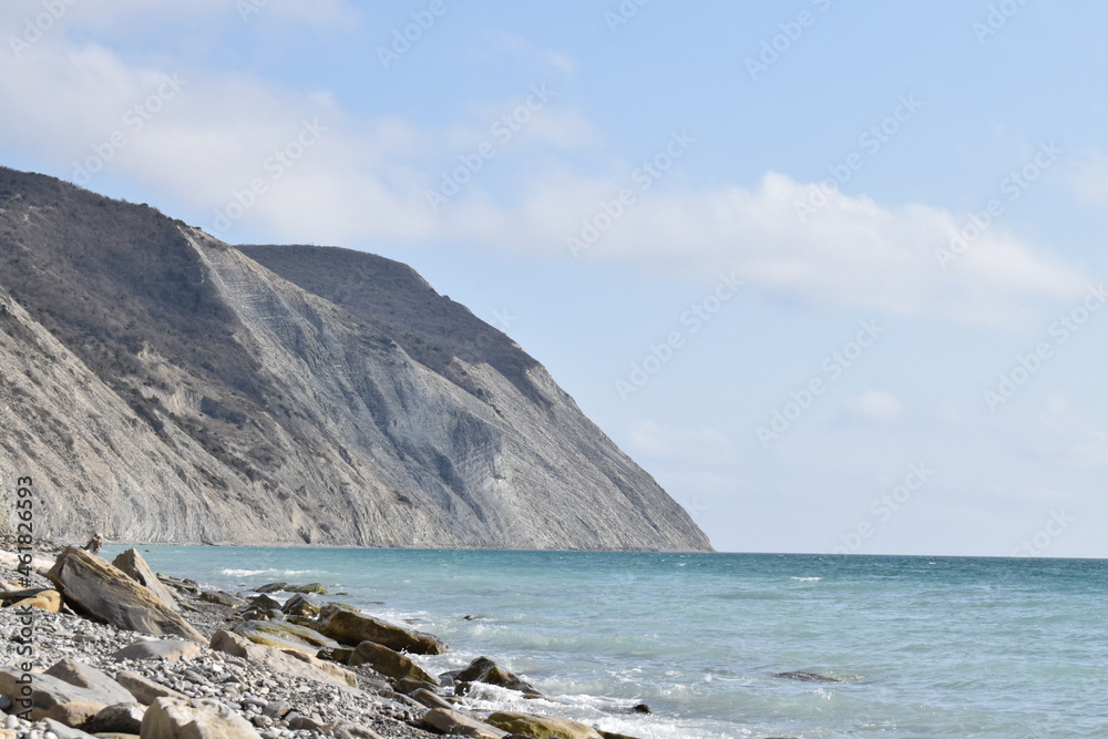 Sea and pebble beach. Types of the Black Sea. The outskirts of Anapa. Mountains and rocks, pebble beach, seagulls.
