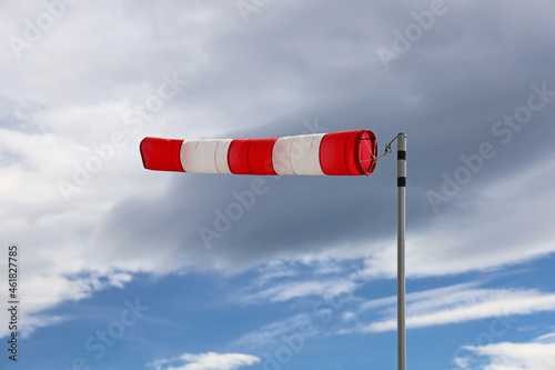 Foto close up of red and white windsock indicator on cloudy sky