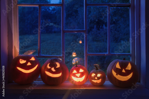 Halloween pumpins on windowsill with ghost outside  window photo